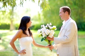couple just married with man holding flowers in hand