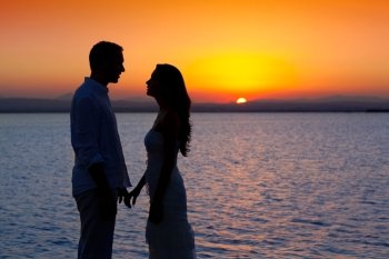 couple in love back light silhouette at lake orange sunset