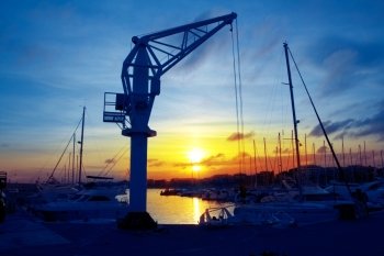 boats crane at sunset in marina port of Salou Tarragona Spain