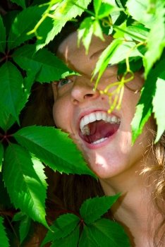 happy woman face in foliage