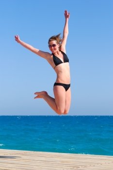 beautiful woman jumps near the sea