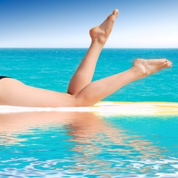 beautiful female legs between a pool and sea