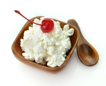 Cottage cheese with cherry in a wooden bowl