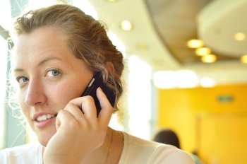 young woman is talking phone and looking at camera