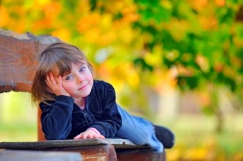 little girl laying down on a bench