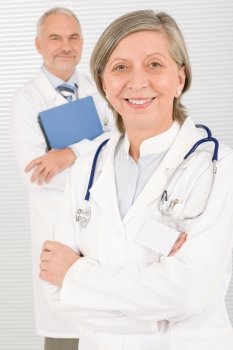Medical doctor team mature woman and senior man holding folders