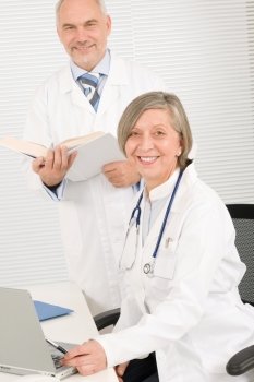 Medical senior doctor female work computer with professional male colleague