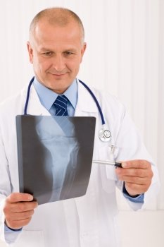 Portrait of professional male doctor look down and point x-ray