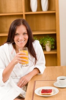 Breakfast orange juice and toast happy woman in home bathrobe