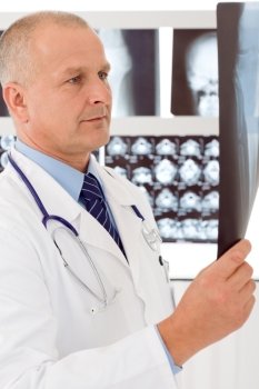Male doctor standing at front of set x-ray looking