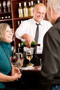 Wine bar senior couple enjoy drink smiling barman pour glass