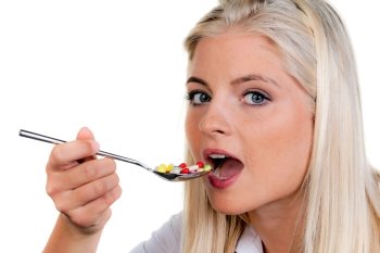 young woman with a lot of pills on a spoon: