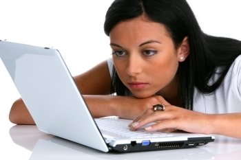 a young woman writes on a laptop computer