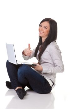 Eine junge Frau schreibt auf einem Laptop Computer