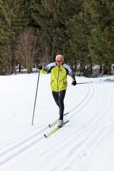 senior in winter cross country skiing on snow with skis