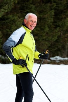 senior in winter cross country skiing on snow with skis