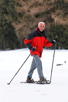 elderly man in winter on snowshoes
