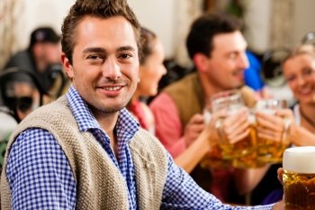 Inn or pub in Bavaria - man in traditional Tracht drinking beer 