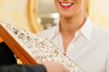 Shop assistant at the jeweler with jewelry