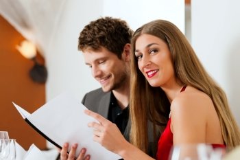 Couple looking into menu of restaurant for their dishes