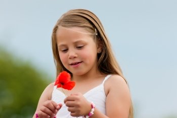 Family - Happy girl with corn poppy in summer