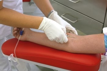a woman donates blood at a blood lab. blood transfusions can save lives.