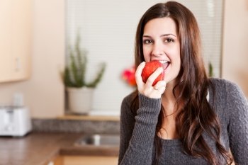 A shot of a young woman eating an apple