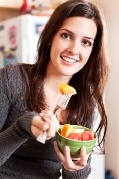 A shot of a young woman holding a fruit bowl