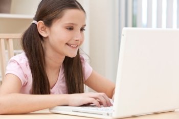 Girl Child Using Laptop Computer At Home