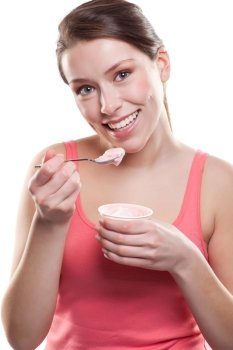 An isolated shot of a beautiful sporty caucasian woman eating yogurt