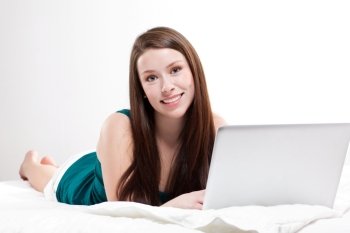 A shot of a caucasian woman with laptop on her bed