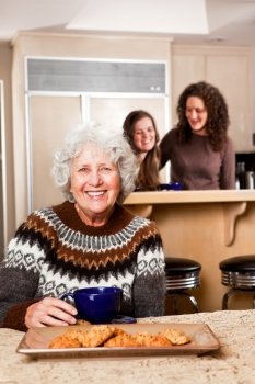 A portrait of a senior lady at home with her daughter and granddaughter