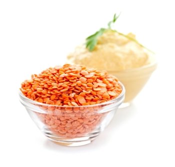 Red lentils and lentil hummus in bowls on white background