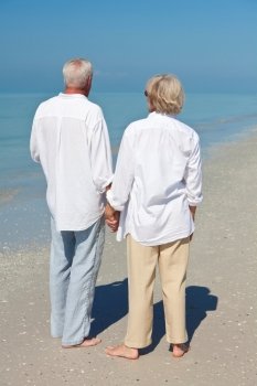 Happy Senior Couple Holdings Hands on A Tropical Beach