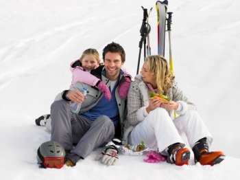 Young Family With Picnic On Ski Vacation