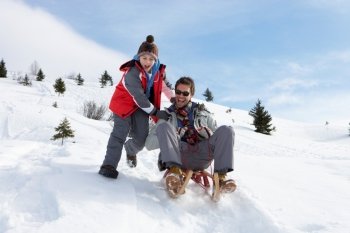 Young Father And Son Sledding