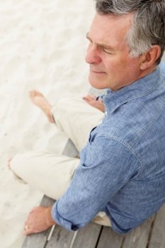 Senior man sitting by beach