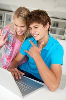 Teenage boy and girl using laptop