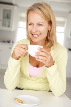Mid age woman with coffee at home