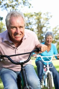Senior couple playing on children´s bikes