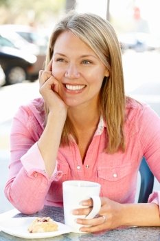 Woman sitting at sidewalk cafe