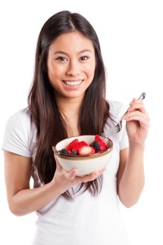 An isolated shot of an asian woman holding a bowl of fruit