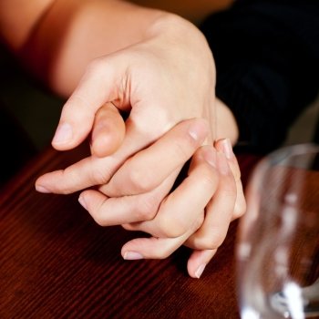 Couple holding hands on a table, probably in a restaurant