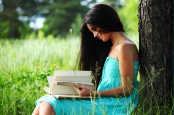 girl with book under big tree