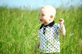 little boy play in green grass