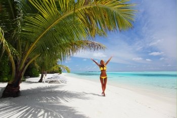 woman in bikini under palm on sea background