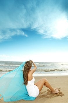 woman laying on sand sea on background