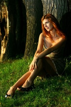 young beautiful Woman sitting under the tree in forest