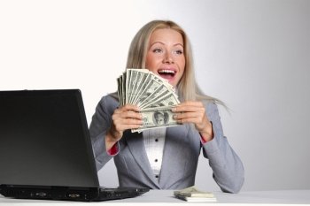 business woman working on laptop dollar in hands