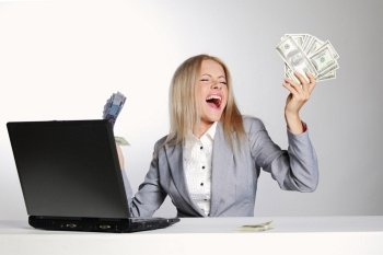 business woman working on laptop dollar in hands